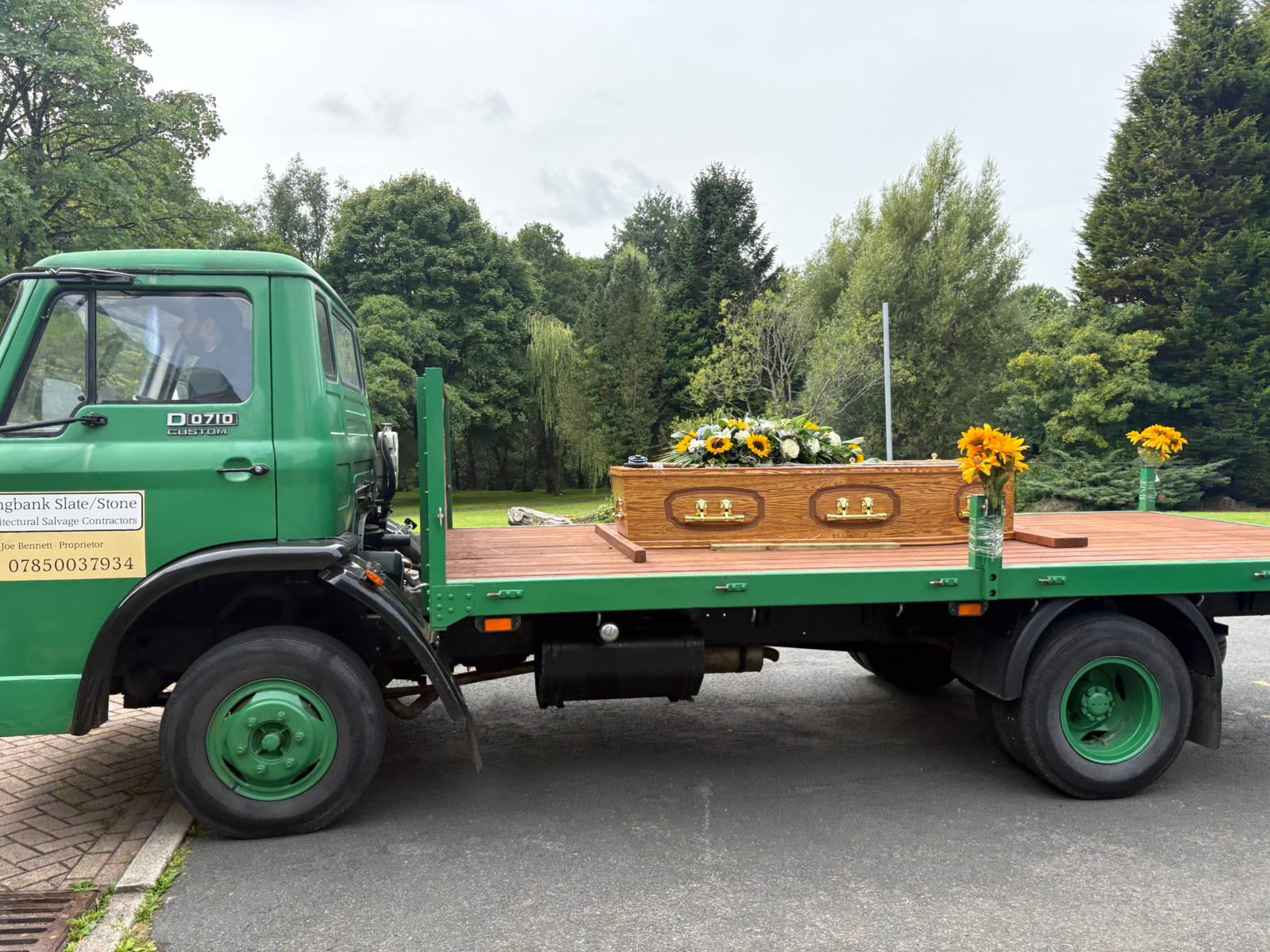 Close detail of the coffin and floral spray on the carriage bed